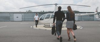 Молодая модная пара идет навстречу пилоту белого частного вертолета