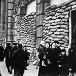 Жители на улице блокадного Ленинграда у зданий